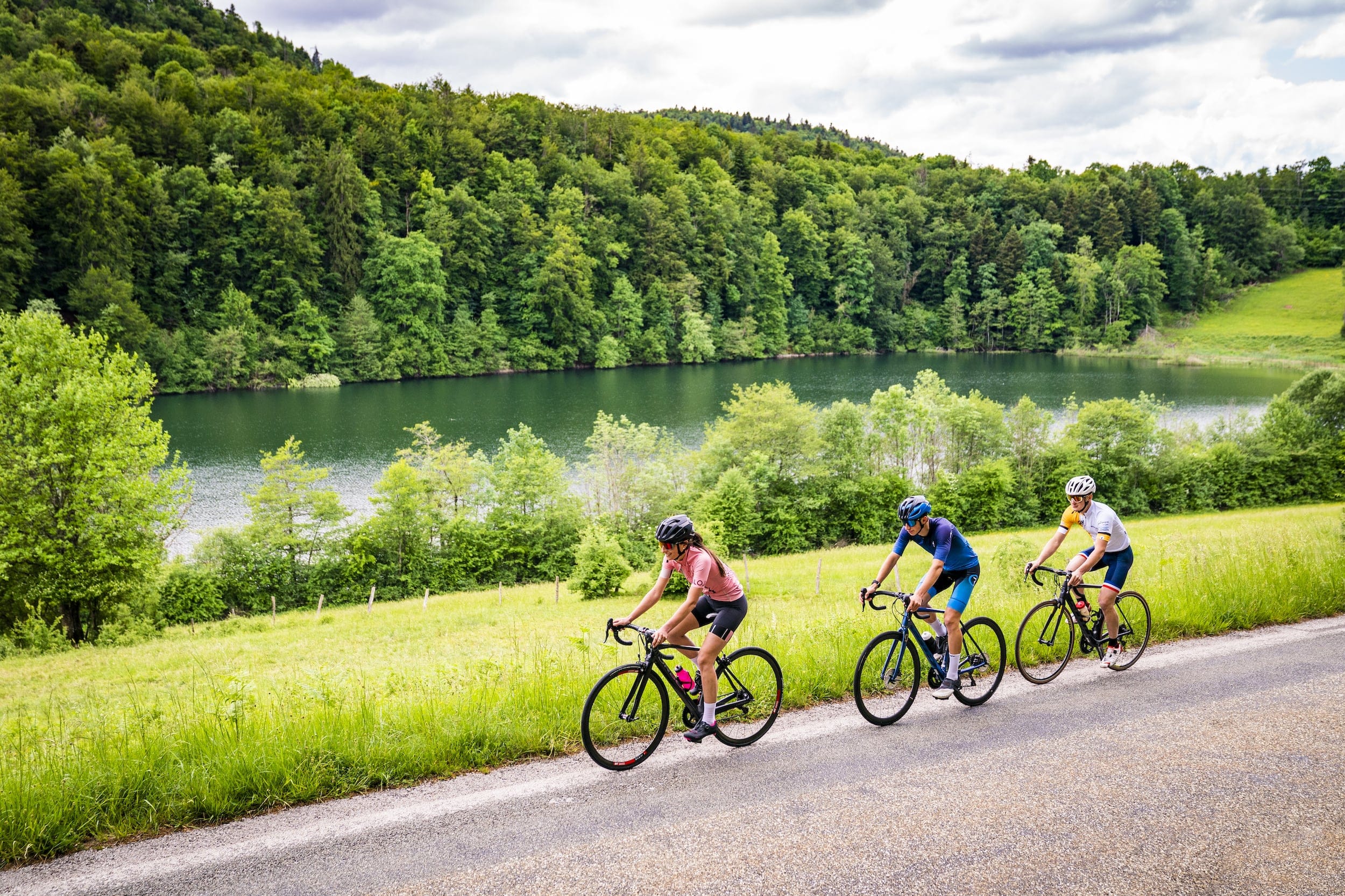 3 cyclists at the edge of a lake